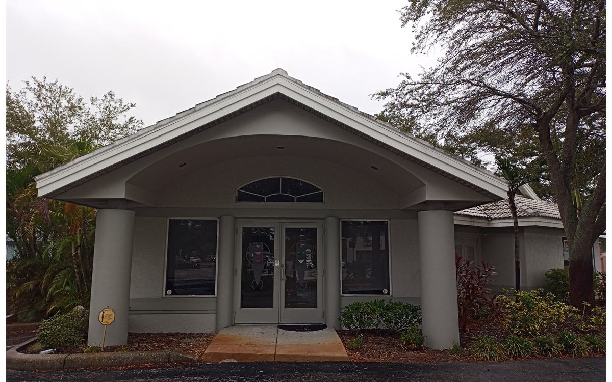 Dingy HOA community clubhouse with stained entry walkway before Sandbar soft washing — real job photo