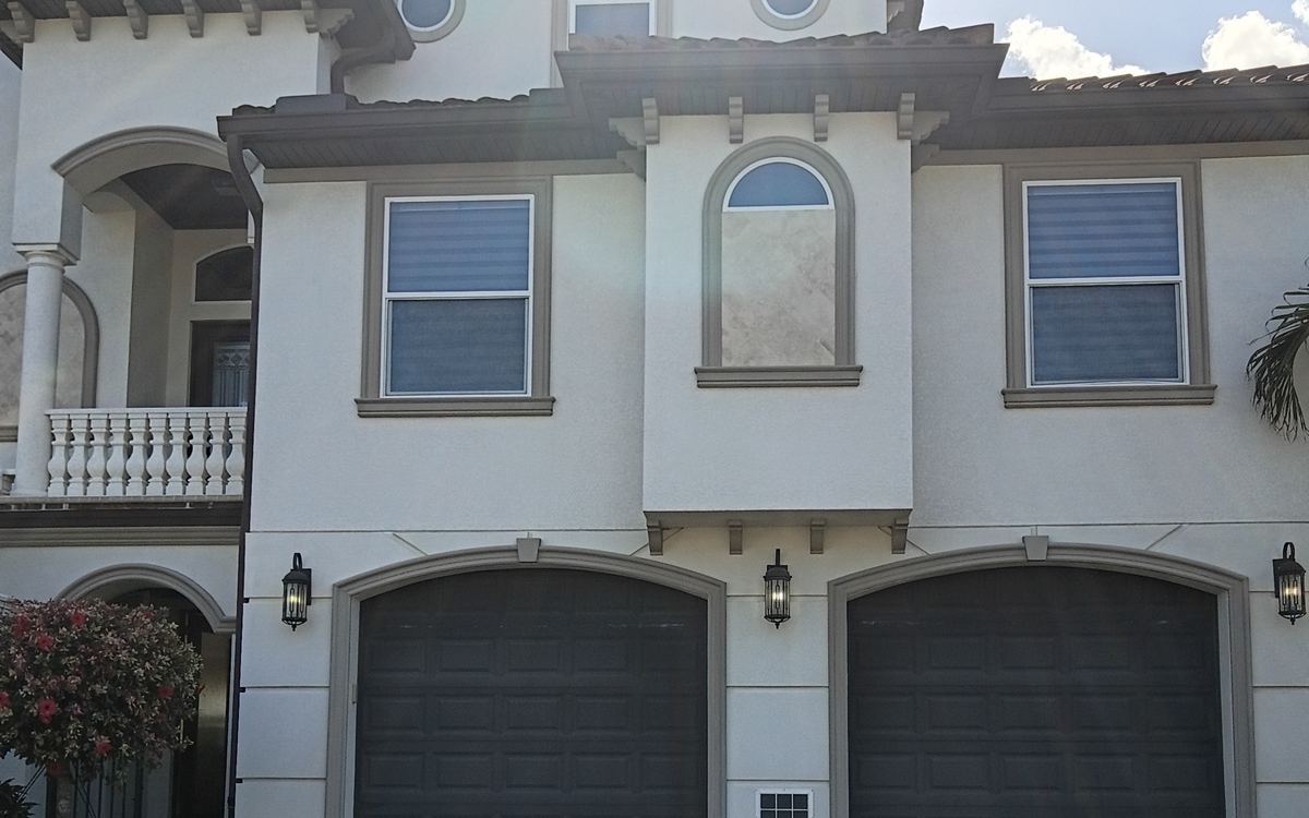 Three-story Mediterranean stucco home with paver drive after a Sandbar house soft wash — real job photo
