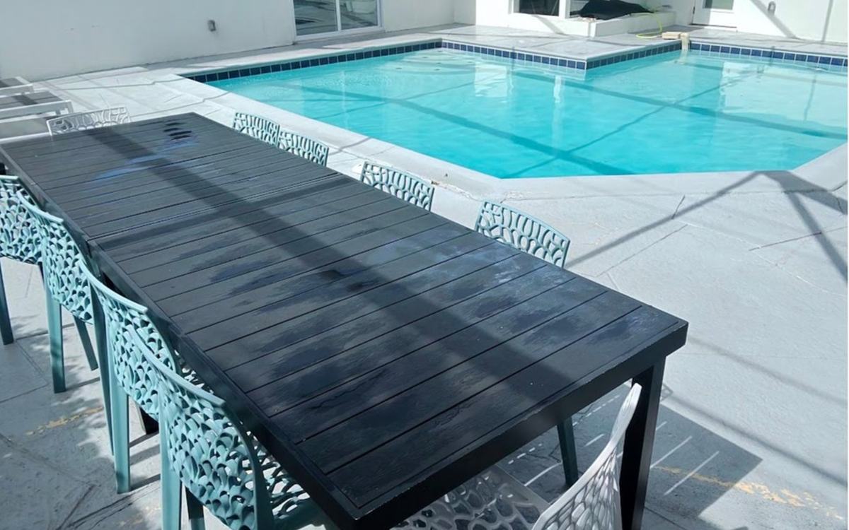 Clean lanai dining area and pool after Sandbar deck cleaning — real job photo