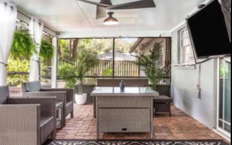 Covered residential screened lanai with wicker patio furniture, soft washed
